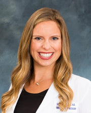 A smiling woman, headshot. Her expression conveys warmth, reflecting the nurturing and supportive ethos of prenatal wellness products from WeNatal.